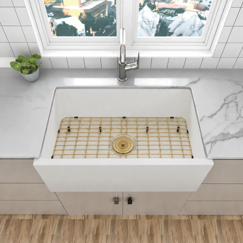 White quartz composite apron front kitchen sink with gold bottom grid and gold drain