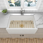 White quartz composite apron front kitchen sink with gold bottom grid and gold drain