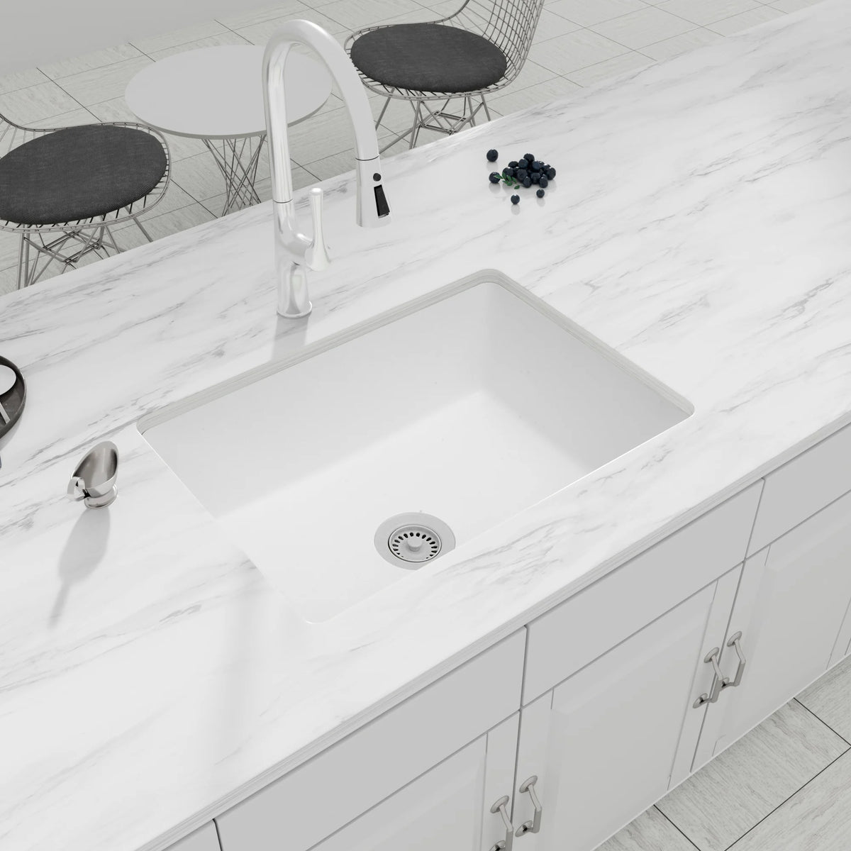 White quartz composite undermount single bowl kitchen sink installed in a marble countertop