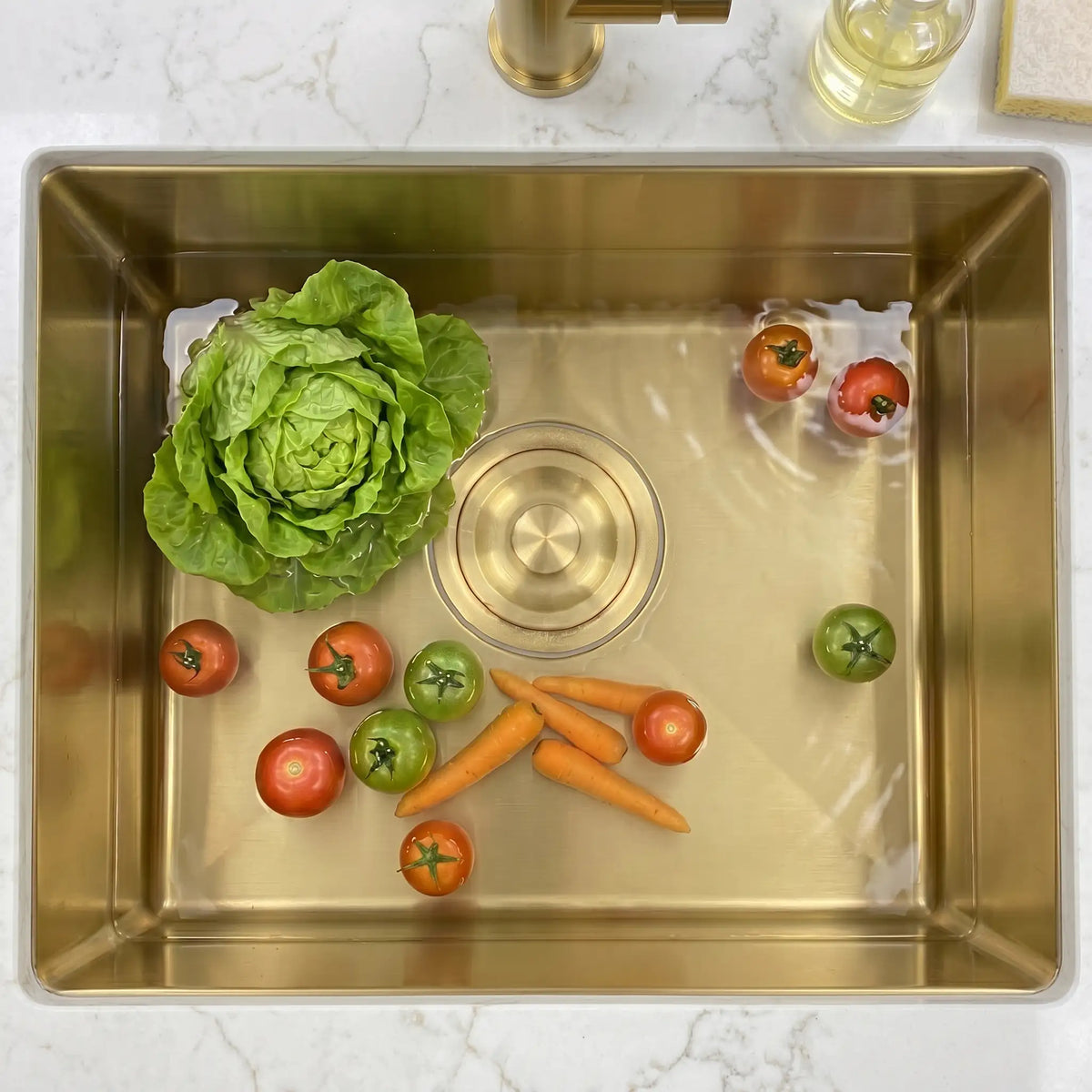 Gold kitchen sink drain stopper installed in sink