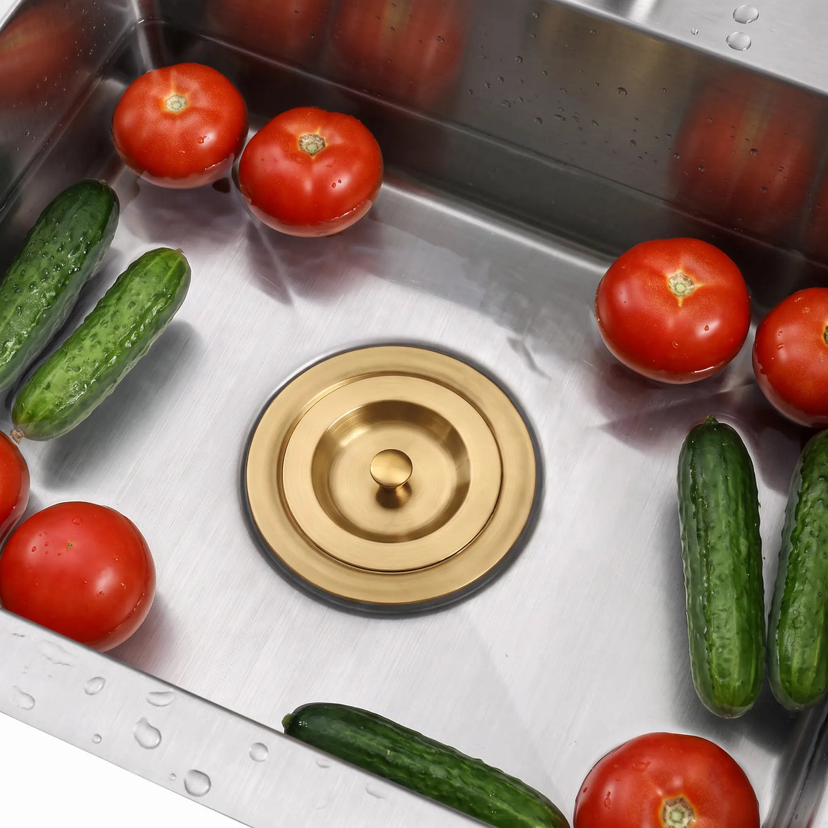 Gold sink stopper installed in a stainless steel kitchen sink