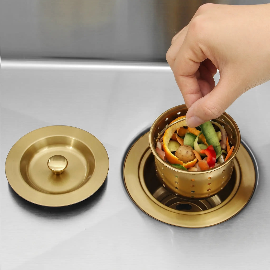 Removable basket strainer holding food scraps in a gold kitchen sink drain