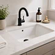White bathroom sink with black faucet in a modern vanity